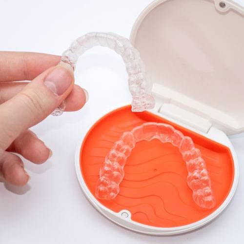Transparent aligners retainers in a storage case. Invisible brac